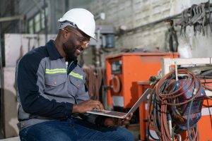 african-american-male-engineer-using-computer-laptop-control-robot-arm-welding-machine-industrial-factory
