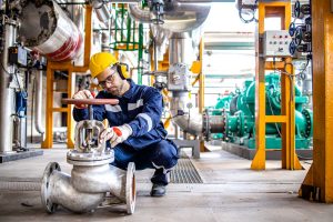 hardworking-industrial-technician-inspecting-high-pressure-valve-inside-refinery-plant